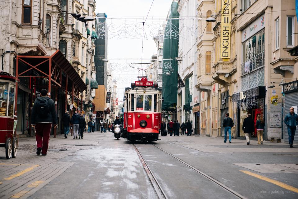 walking trolley streets streetcar stores shops people pedestrians city buildings architecture 