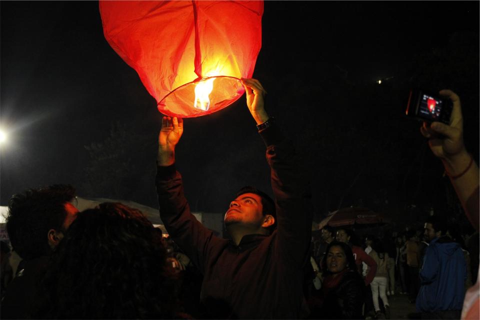 spectators photographers people night man lantern guy fire dark crowd 