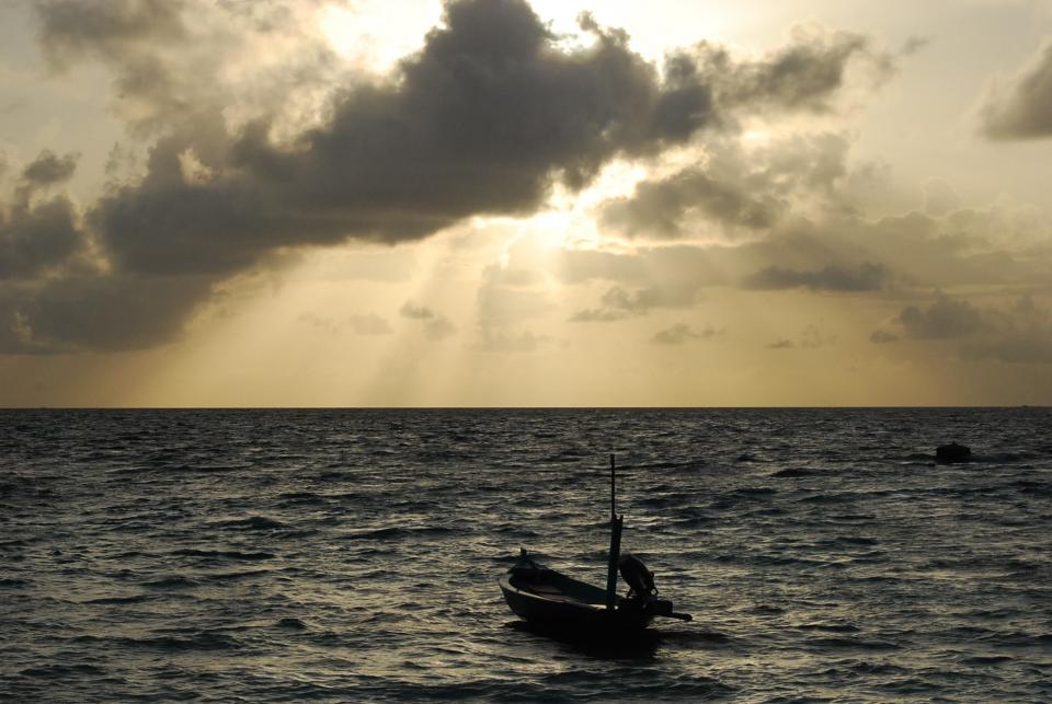 water sunset sunbeams sea ocean horizon clouds boat 