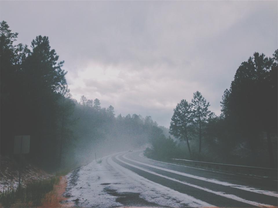 woods winter trees snow sky road highway guardrail grey forest fog cloudy clouds car 