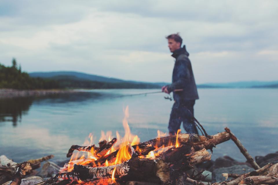 young water people nature man lumber logs lake guy flames fishingrod camping bonfire 