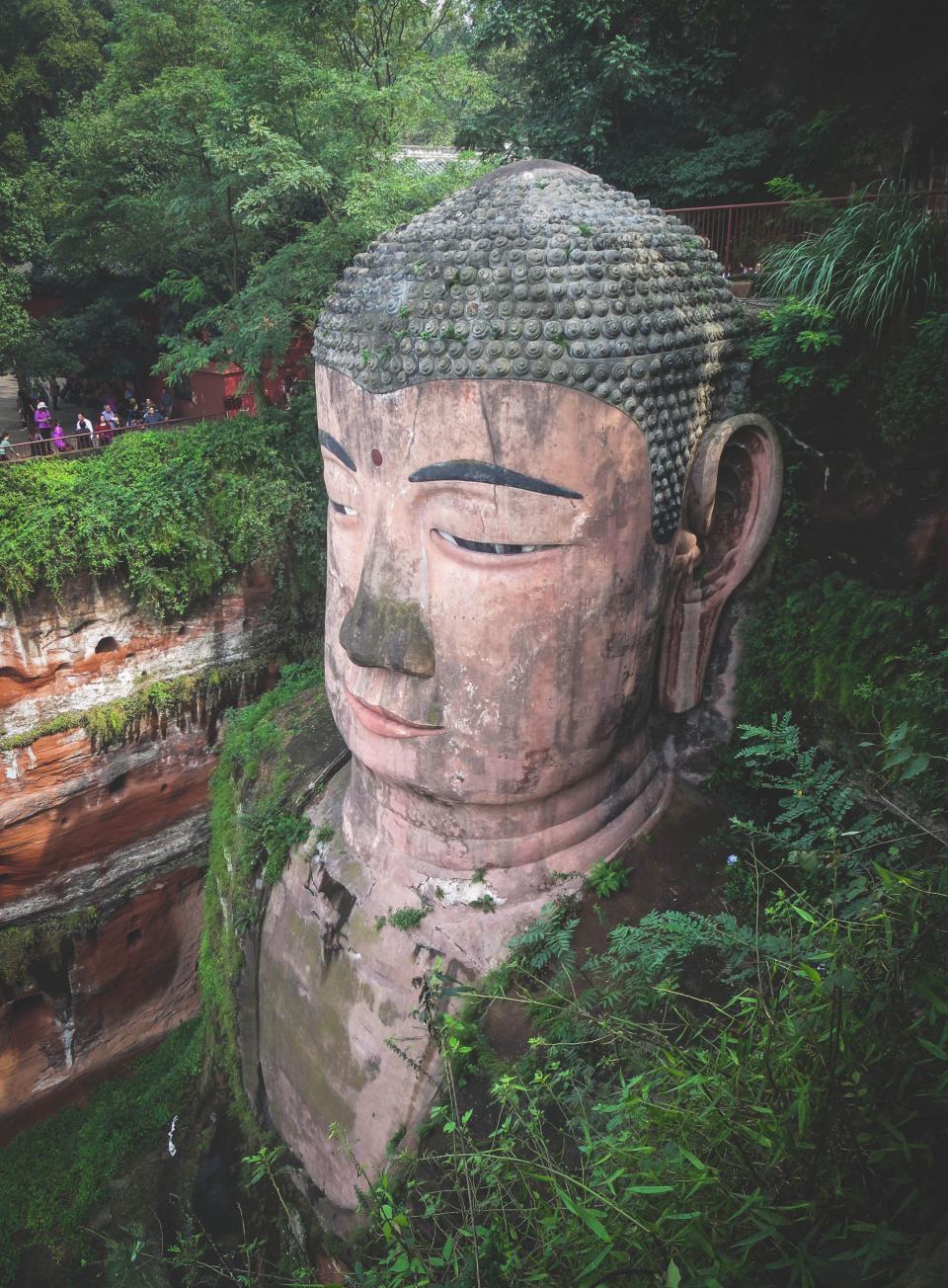 tourists statue Sichuan plants people LeshanGiantBuddha leaves culture china Buddhist Buddhism 