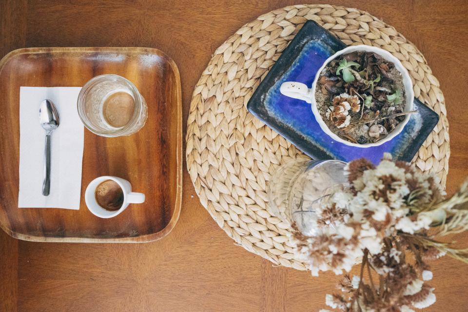espresso, coffee, drink, beverage, cup, glass, tray, wood, table, napkin, spoon, plant, vase, placemat
