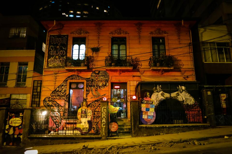 Building in La Paz, Bolivia, graffiti, mural, art, spray paint, building, windows, railings, sidewalk, dark, night, entrance