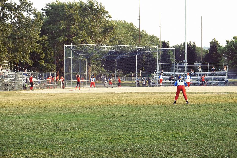 umpire sports spectators park mound grass field dirt diamond bleachers baseball athletes 