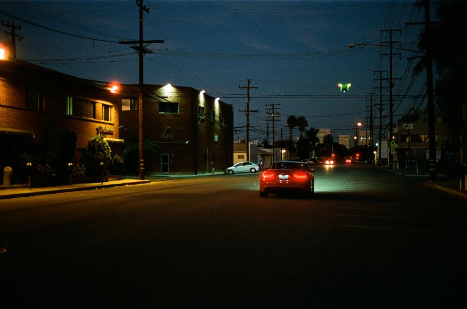 street road red powerlines night lights evening dark car 