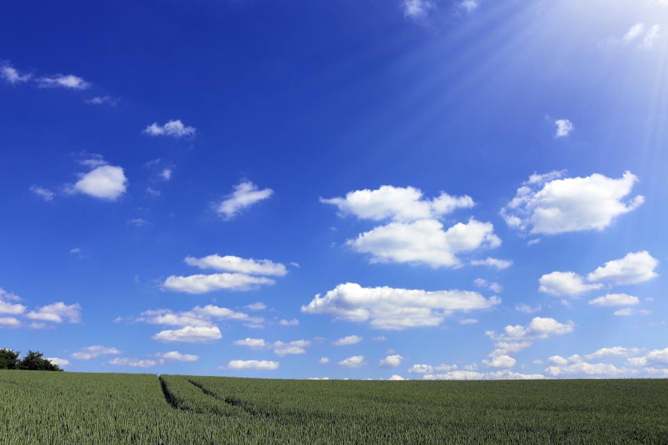 sunshine sky green grass fields clouds blue 
