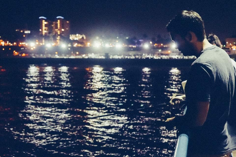 water tshirt rod pier night man lights fishing evening dark city 