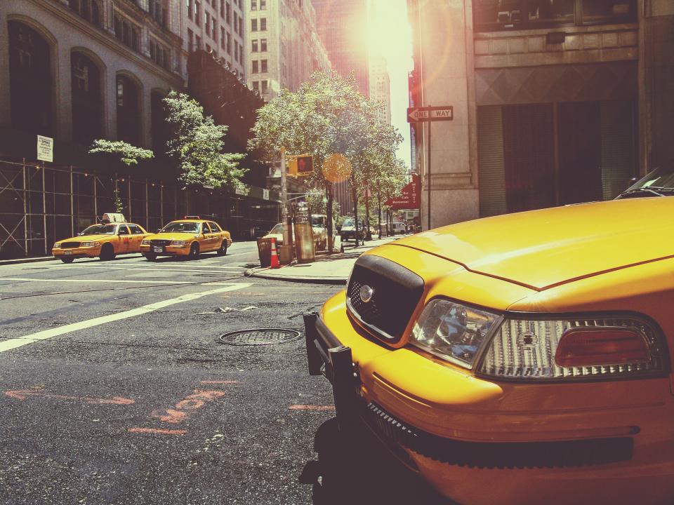 yellow towers taxis streets signs roads pavement NewYork manhole intersection city cars cabs buildings 