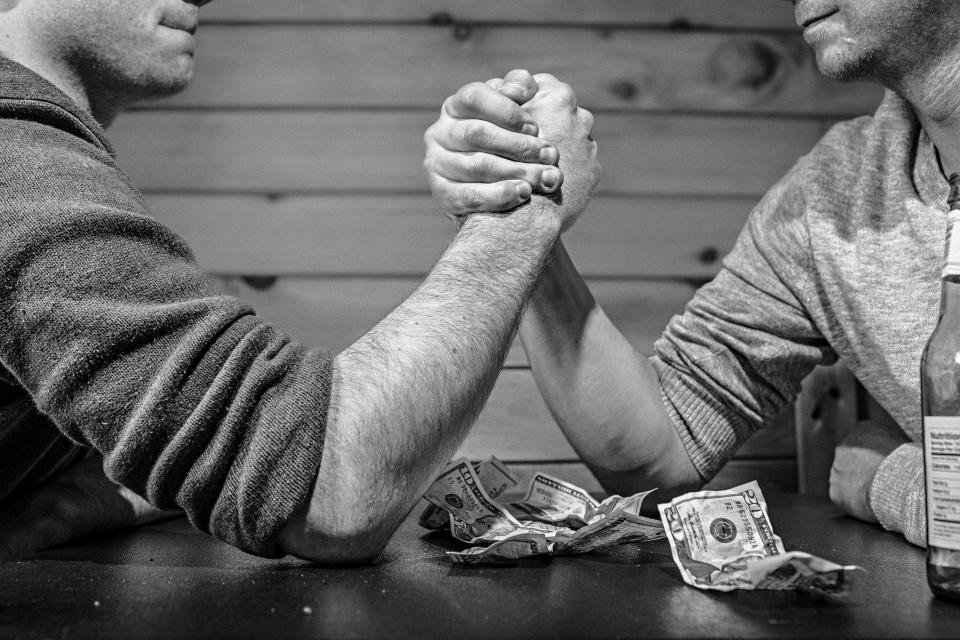 table strong strength money men hands gambling bills betting armwrestling 