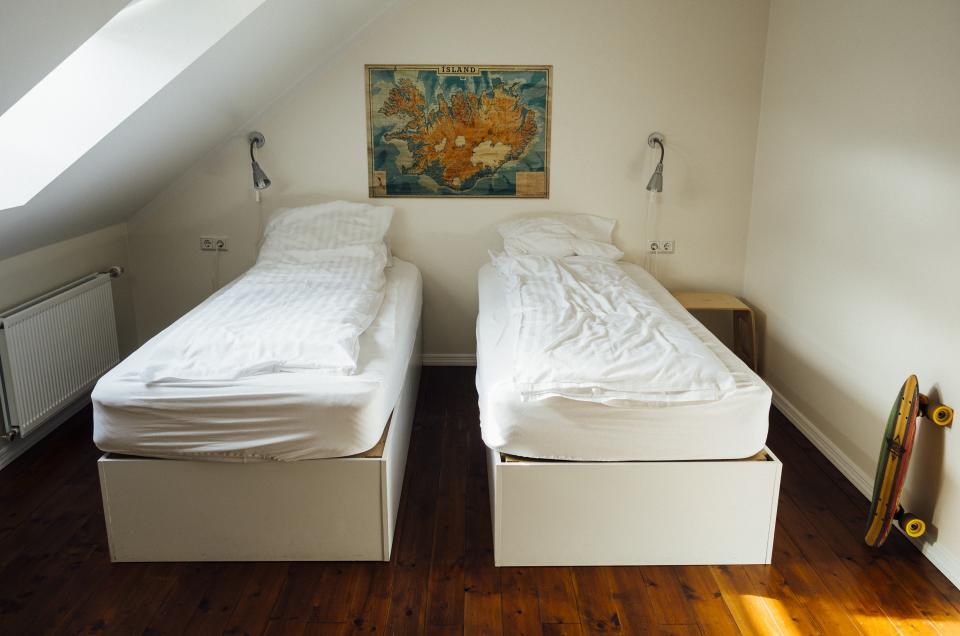 white walls skateboard sheets room pillows longboard lamps hostel hardwood floors covers beds 