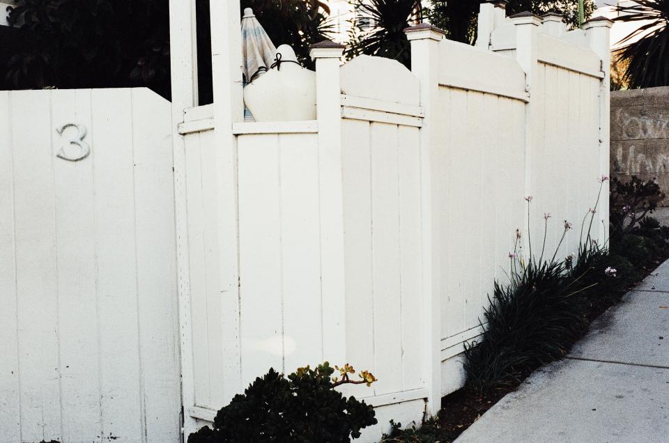white sidewalk house gate fence 