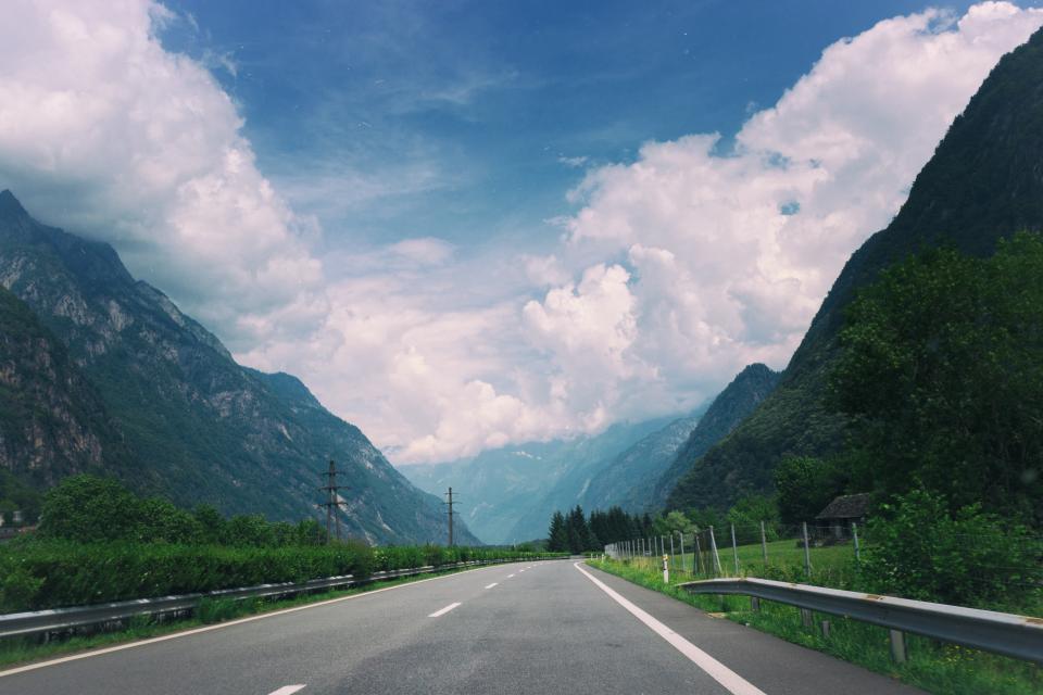 travel sky road railing powerlines mountains hills highway driving clouds blue 