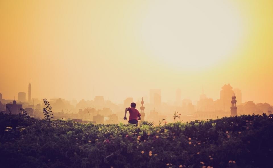 yellow, sky, sun, boy, running, grass, fields, buildings, city