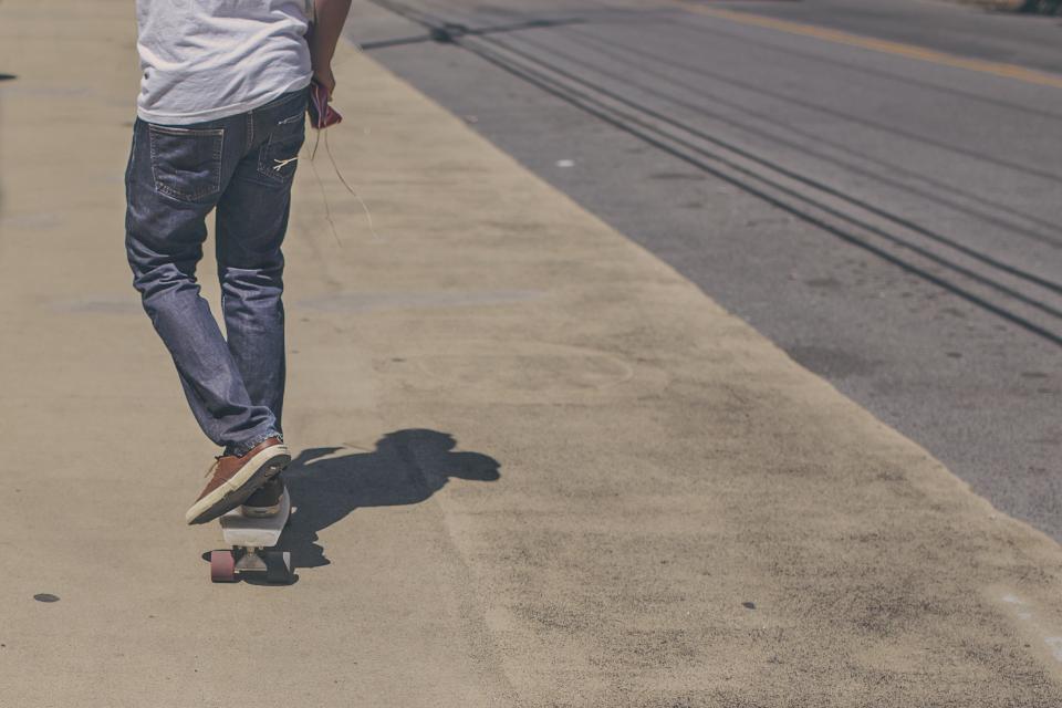 street skater skateboarding sidewalk shoes pavement pants jeans 