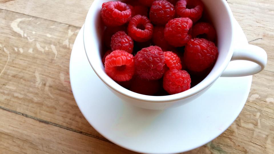 wood table red rasberries mug Healthy fruits food eat cup breakfast 