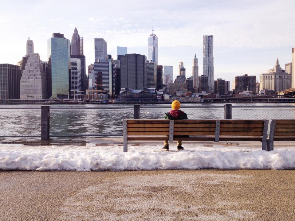 winter waves water view towers skyscrapers skyline NewYork man cold city buildings boy bench 
