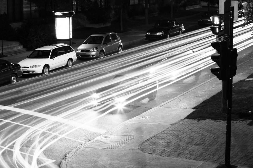 trafficlights street signs sidewalk road parking parked night lights driving dark concrete cars 