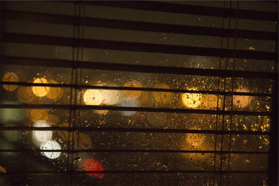 window raining night lights dark blurry blinds 