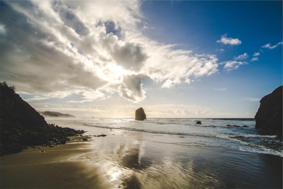 water sunshine sky shore sea sand rocks reflection ocean clouds beach 