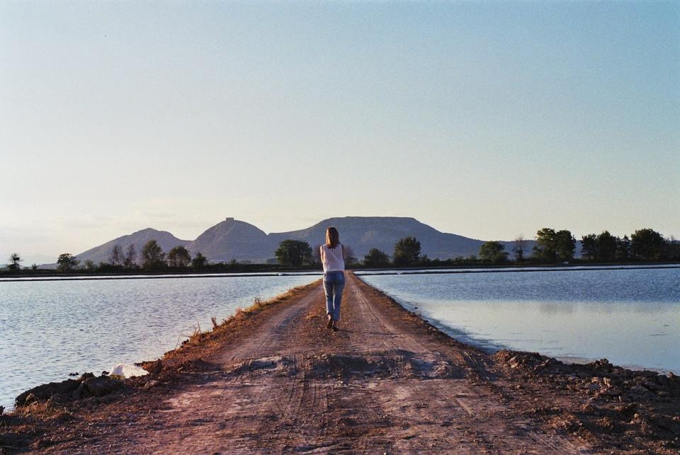 water walking sunshine sunny sky people path outdoors mountains lake jeans girl dirt 