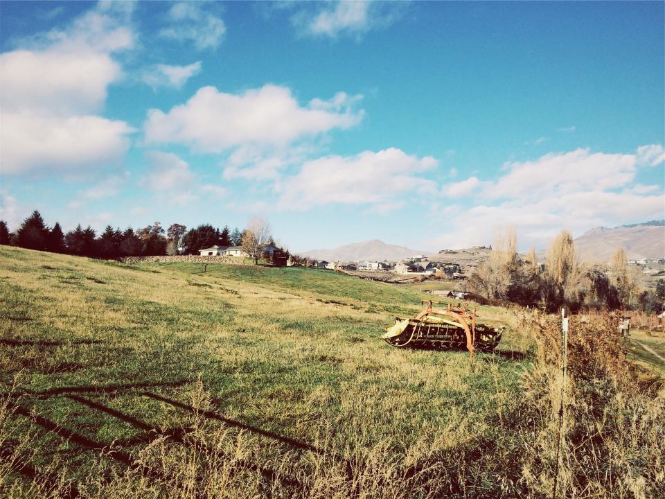 town sunshine sunny sky rural houses hills grass fields clouds blue 