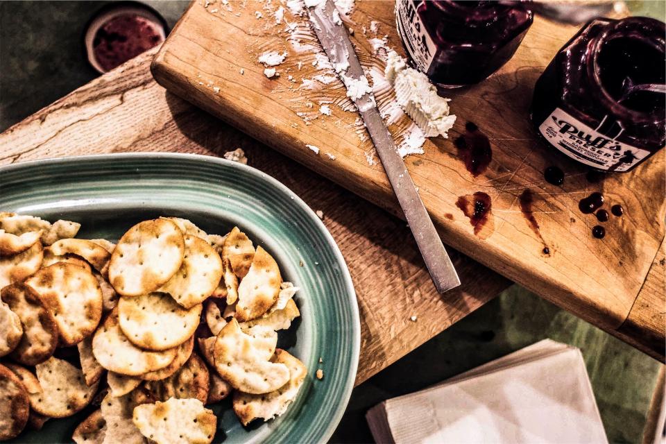 snack knife jam food cuttingboard crackers cheese 