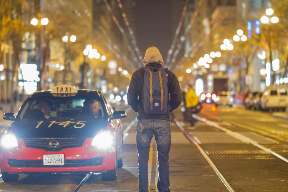 urban taxi street road people pants night light lampposts jeans jacket hoodie evening driving city cars backpack 