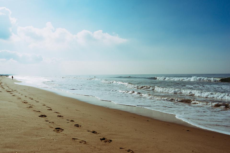 waves sky shore sea sand ocean footprints blue beach 