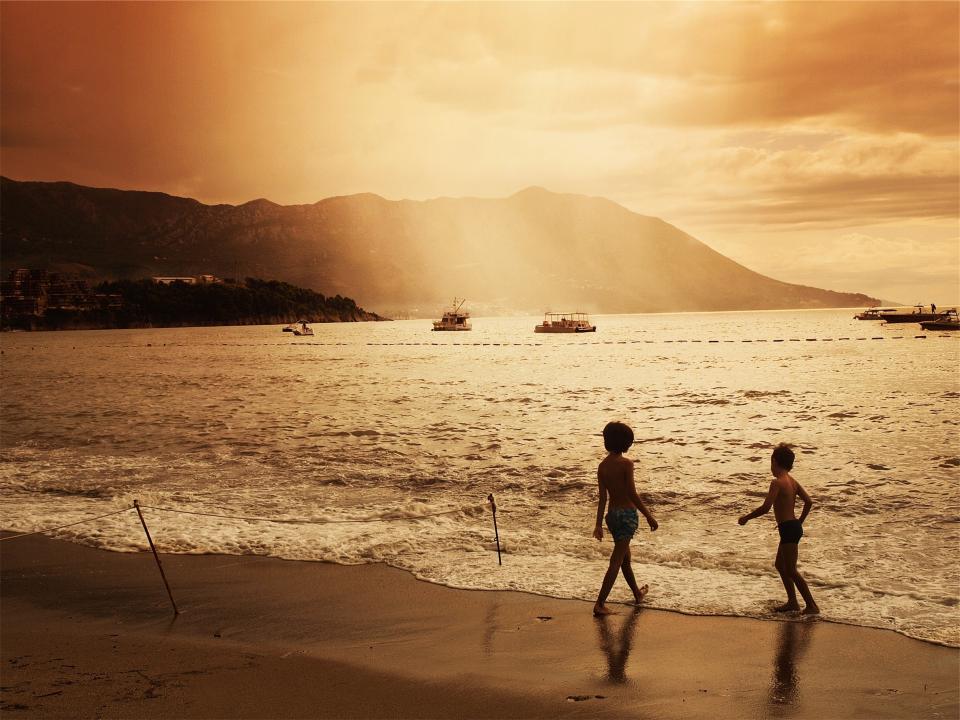 waves water sunset sky ships sea sand playing people ocean mountains kids dusk clouds children boats beach 