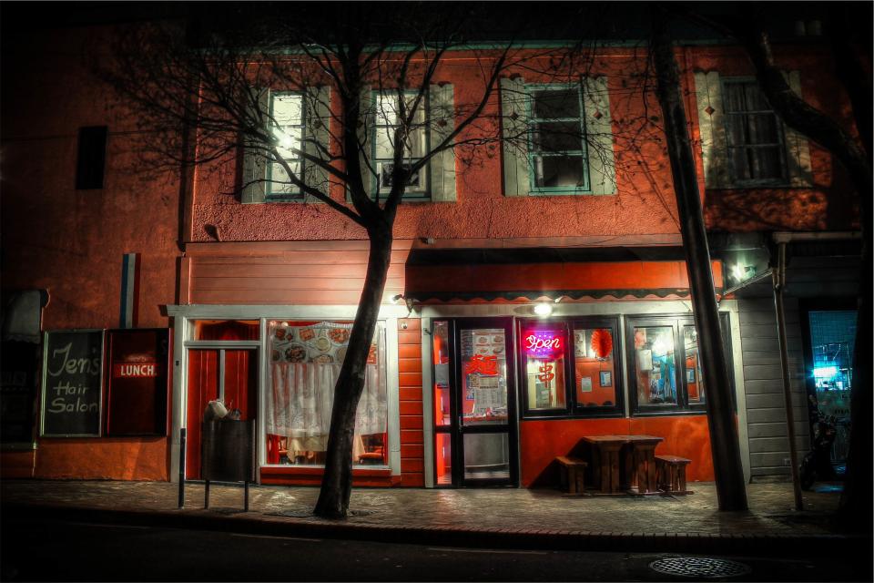 Windows street sign sidewalk restaurant open night neon evening dark building 