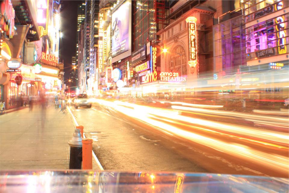 street signs sidewalk night neon lights LED evening entertainment downtown city cars 