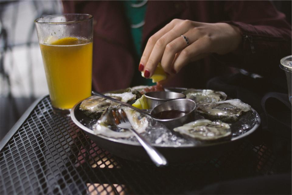 squeeze shells seafood oysters lemon ice hands glass forks beer 